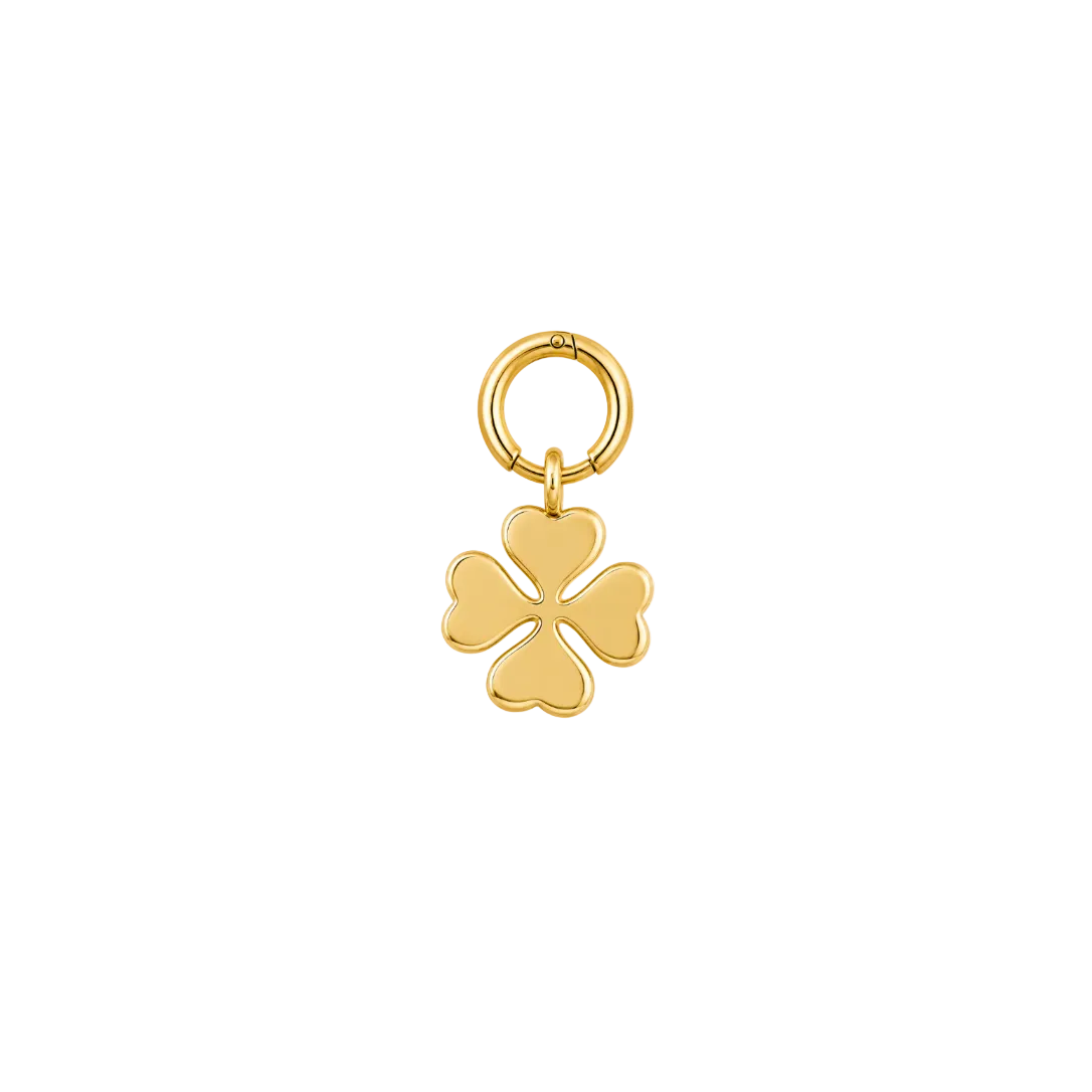 A polished gold charm featuring a four-leaf clover design with a small split heart in the center, suspended from a circular ring, shown on a plain white background.