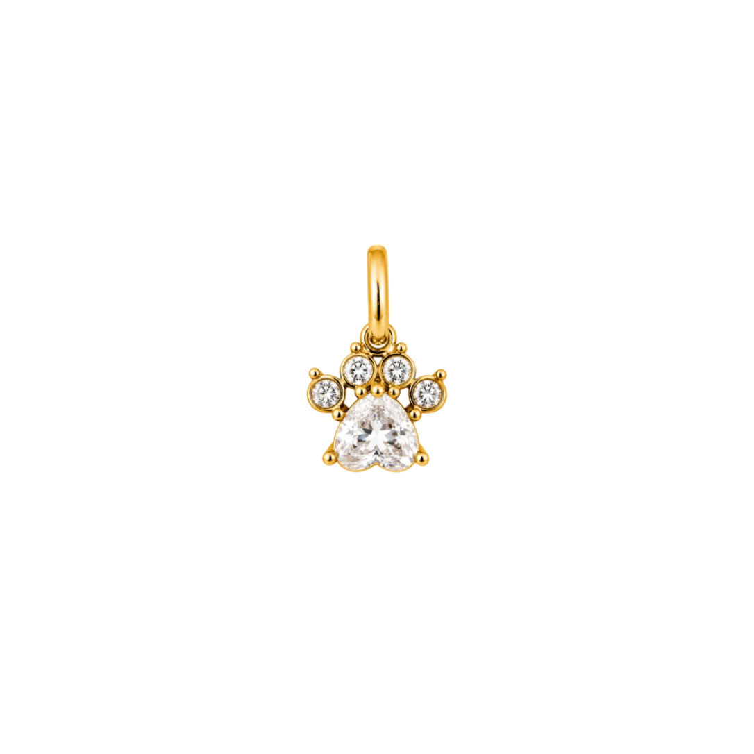 A gold paw print charm pendant featuring a clear heart-shaped gemstone and three small round clear stones, shown on a plain white background.